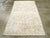 A vintage Indian Cotton Agra rug. A modified allover Herati pattern in beige and ecru softly covers the rust field of this...