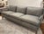 Stylish Studio a Home Laguna Sofa. Gray textured fabric, 3 seats, wood frame. Original Retail $5097. Showroom floor sample.