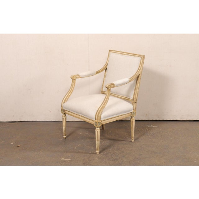 A French Louis XVI style square-back armchair from the Mid 20th century. This vintage chair from France has a square-...