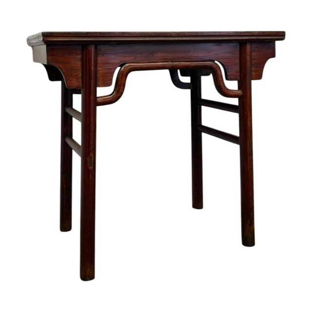 This dark-stained solid wood console table features classic Chinese joinery, highlighted by a decorative camel-hump shaped...