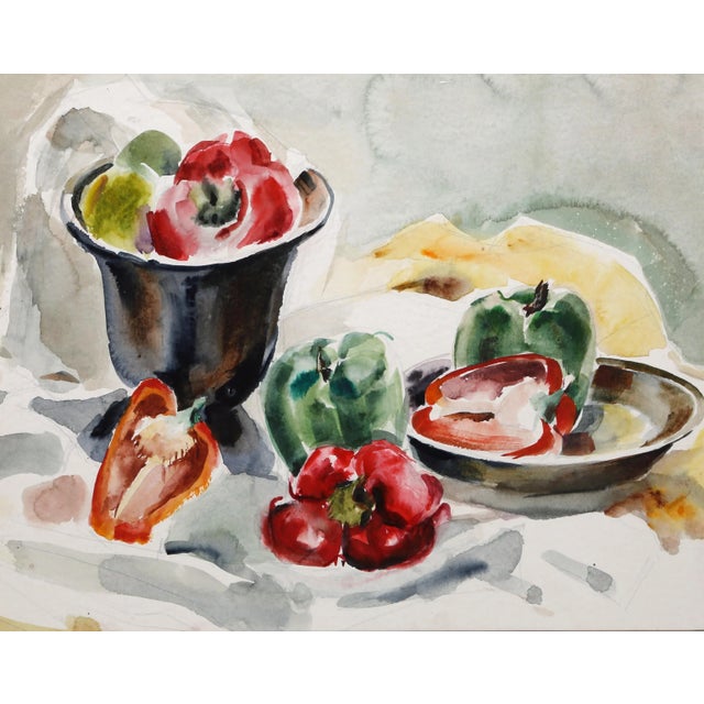 Set across a white tablecloth layered over itself, a series of red, green, and orange bell peppers sit in platters, bowls,...