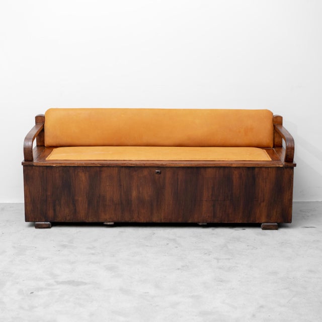 Wooden chest with padded seat and backrest upholstered in leather. Featuring contoured armrests. Large storage...