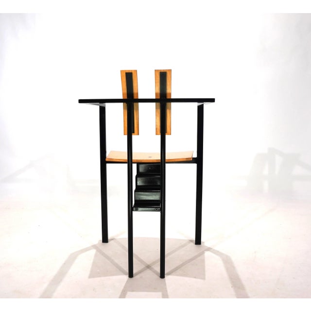 This Trix chair features a black metal frame and a natural-colored seat and backrest. The frame is in very good condition,...