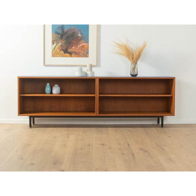 Wonderful sideboard from the 1960s. Body in teak veneer with two shelves and new square steel feet in black. The top was...