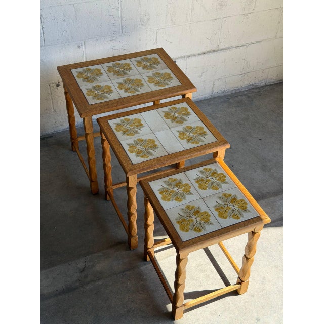 Turned legs support a decorative ceramic tile surface in a versatile set of 3 space-saving accent tables engineered to...