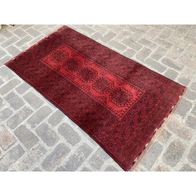Add a touch of tradition to your home with this hand-knotted wool rug, featuring a captivating red tribal Gül design. This...