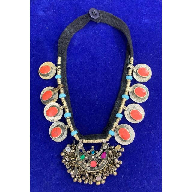 This Afghan Tribal Kuchi Pendant Necklace is a striking piece of bohemian jewelry, showcasing a round coral stone set in...