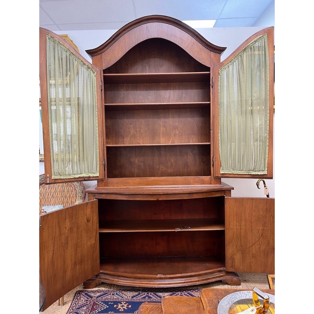 Attractive but she cupboards with arched top and bow front base raised on four bracket feet. Upper cabinet doors featured...