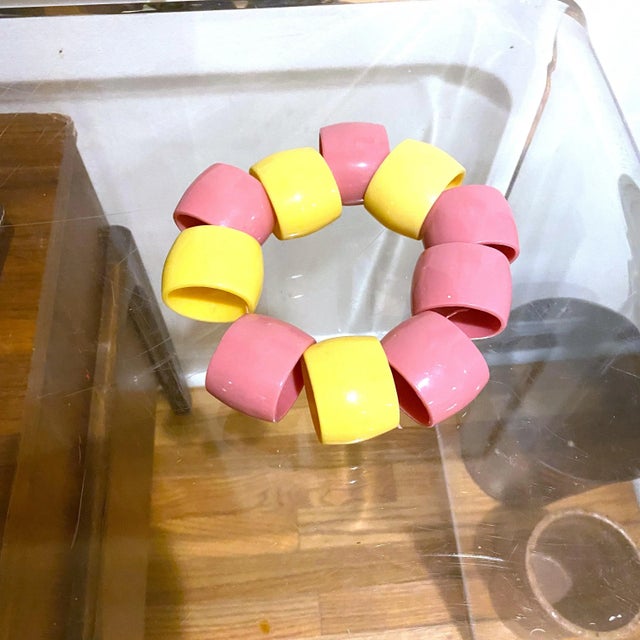 A fun mix of pastel pink and yellow plastic napkin rings. They are oval in shape. There are 6 pinks and 4 yellow.