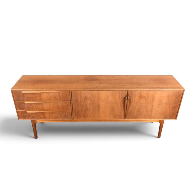 This credenza was designed by Val Rossi and produced by A.H. McIntosh in Scotland during the 1960s. The teak case offers a...