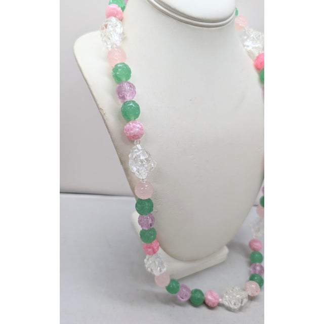 1960s goldtone single strand pink semi-translucscent and opaque pink/white, green, and purple spherical carved resin beads...