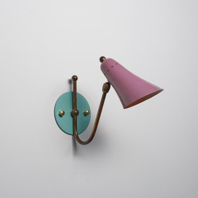 A single italian wall sconce from the 1950s, defined by a balanced combination of form and color. The piece features a...