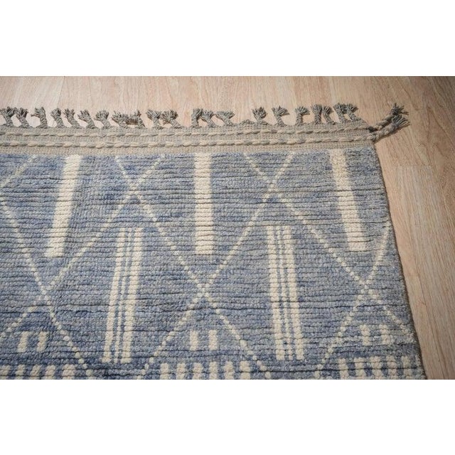 This hand knotted pile rug is crafted from wool and features a primary blue color palette. Designed in the style of a...