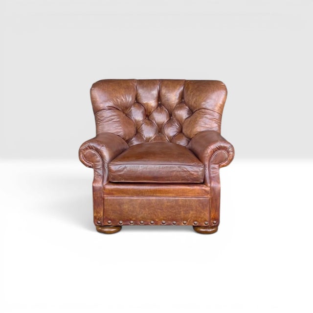 This classic vintage Churchill armchair beautifully embodies the timeless sophistication of classic English club...