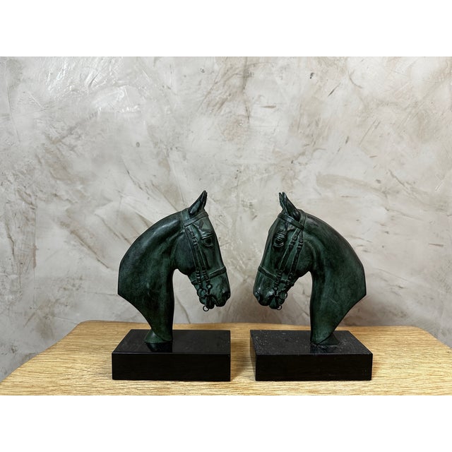 A charming pair of bookends depicting horse heads, crafted in spelter in the 1950s, resting on rectangular black marble...