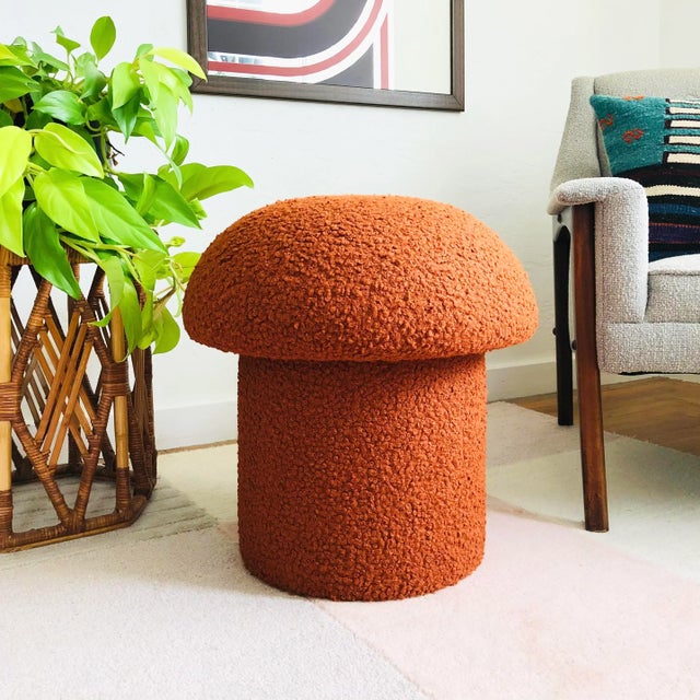A handmade mushroom shaped stool, upholstered in "Cinnamon" curly boucle fabric. Cinnamon is an orange-brown-rust color....