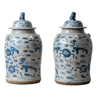 Pair of Chinese Blue and White Glazed Jars With Foo Dog Lid Finials For Sale