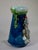 This item is a whimsical majolica monkey and pipe vase featuring brilliant colors, with a monkey wearing a fez hat and...