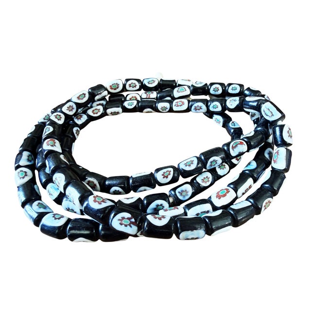 Vintage black and white Venetian Millefiori trade beads centered with red and green flowers. This exceptional strand...
