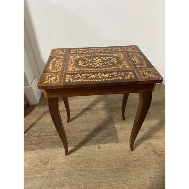 small four legged table . signed made in italy. wonderful marquetry work on this delightful music box table . probably...