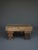 A small coffee table with a rough, unrestored Wabi Sabi or Brutalist appearance. It is made from thick sections of solid...