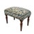 Meticulously handcrafted in the United Kingdom, this upholstered stool boasts classic studding and hand-polished solid...