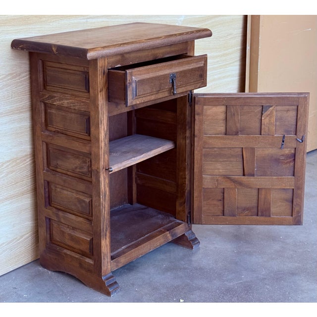 20th century pair of Spanish nightstands with one carved drawer, one door and iron hardware. Beautiful tables that you can...