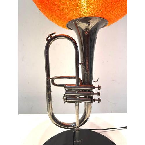 Sculptural vintage table lamp crafted from a repurposed trumpet, transformed into a striking lighting object. The polished...