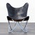 This butterfly lounge chair features a sleek black and brown leather seat with stitched detailing and a sturdy light blue...