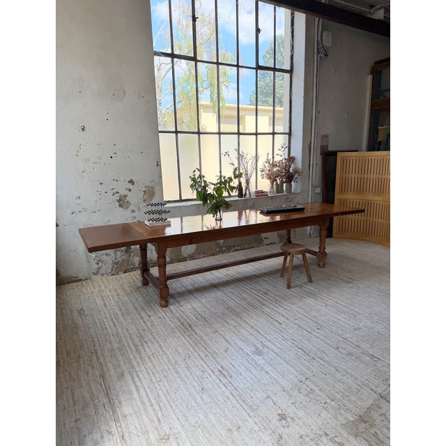 Antique dining table from the first half of the 20th century, crafted from solid walnut. Inspired by drapery designs, with...