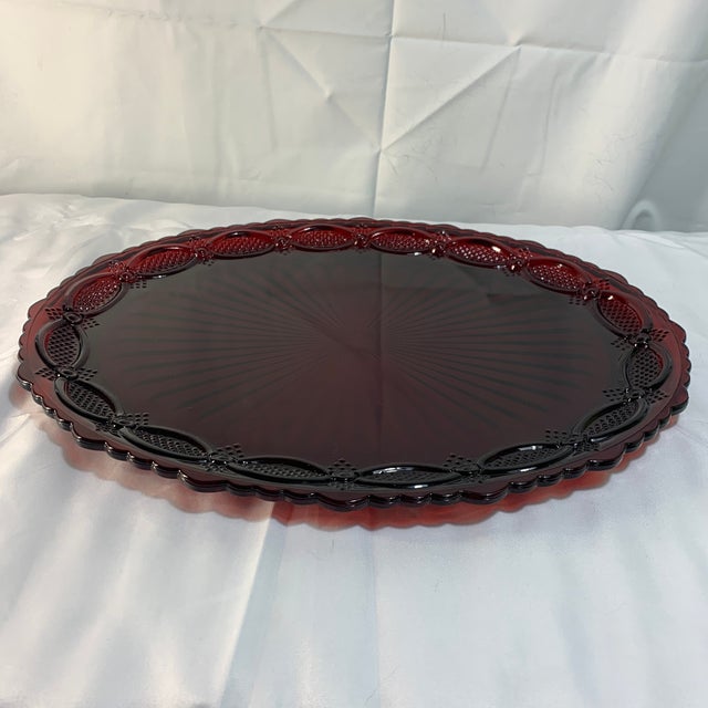 Offered here is a vintage ruby red glass oval serving platter, from the Avon 1876 Cape Cod collection.