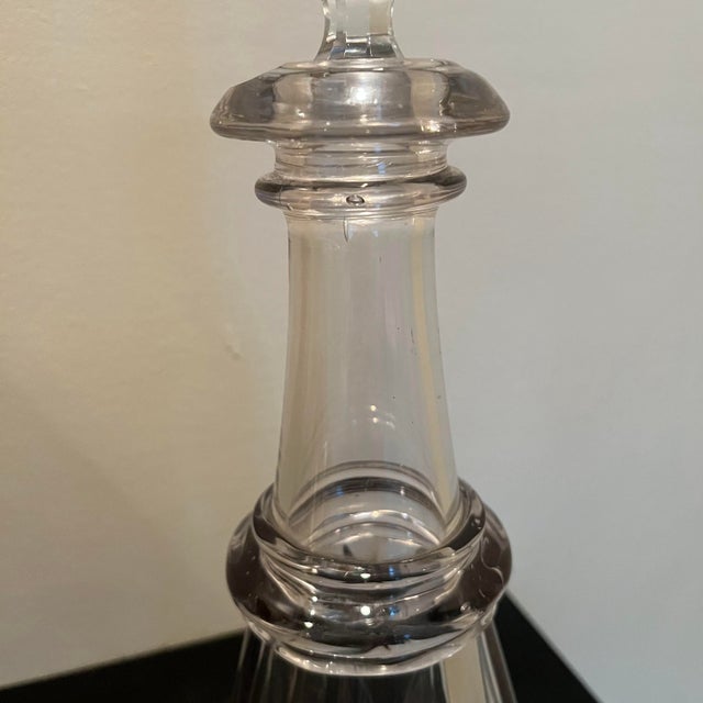 This is an 1850s Victorian glass bottle with a decanter. The bottle is made of clear, hand-blown glass and the decanter is...