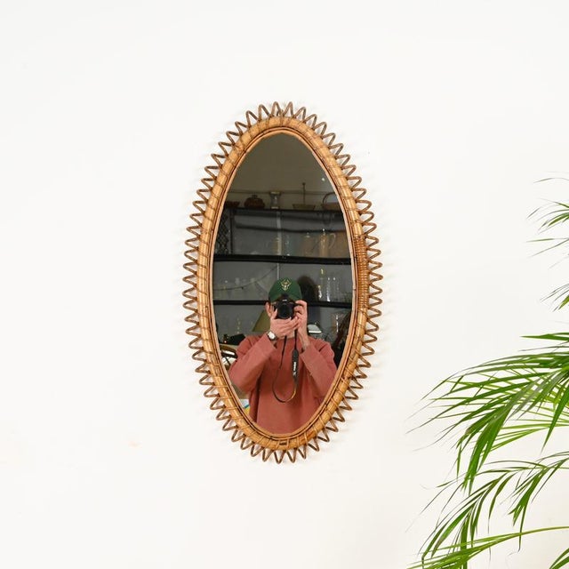 Wonderful Mid-Century large oval mirror entirely made of bamboo, curved rattan, and hand-woven wicker. This incredibly...
