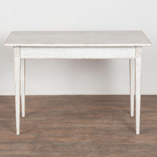 19th century Swedish side table, crafted in pine with a newer layered antique white painted finish. The table is raised on...