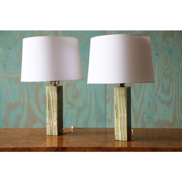 A pair of Green onyx slab lamps. Great striation and graining showing tans and golds. On trend. These lamps would...