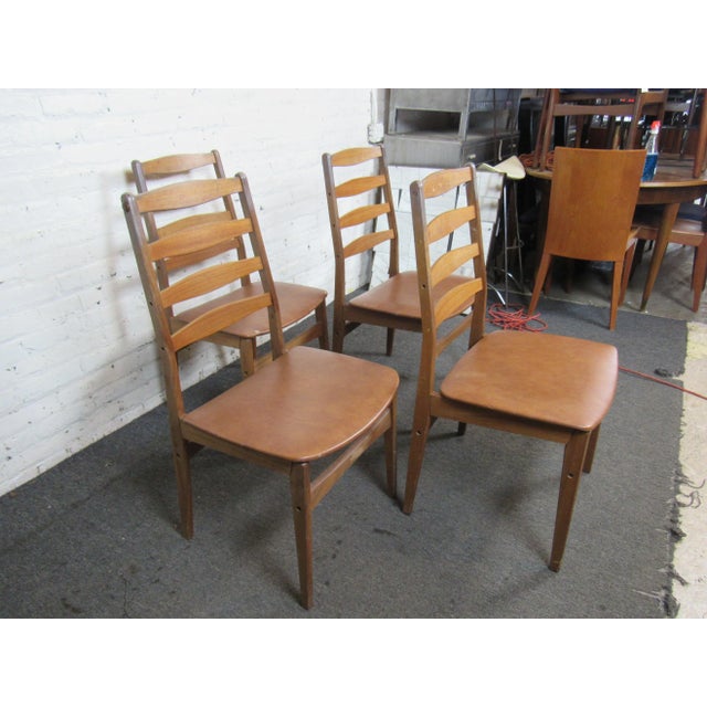 Pairing sculpted teak frames with upholstered vinyl seats, this set of four Danish dining chairs is a great way to add...