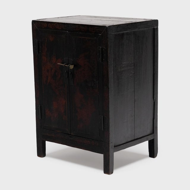 This small painted cabinet is an antique Chinese storage chest from the mid-19th century, a miniature version of a classic...
