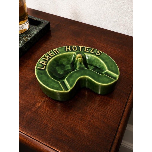Offering a distinctive circa 1940s–1950s ceramic advertising ashtray from Lamer Hotels, a historic Kansas hotel group with...