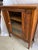 I believe this is an old radio or phonograph cabinet that has been repurposed to be used for storage or display items. The...
