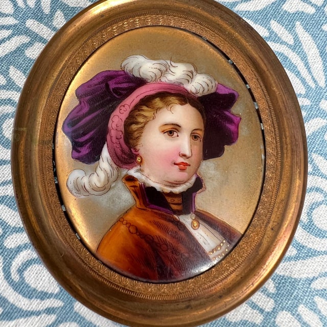 This is a beautiful antique portrait of a woman that has been painted on a porcelain blank and framed in a gold-tone metal...