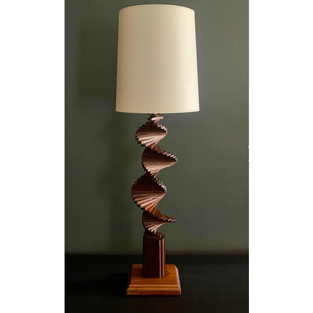 This striking sculptural table lamp is a masterful example of Tramp Art–inspired American folk modernism, carved in...