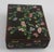 A beautifully crafted vintage Chinese cloisonné enamel box featuring a delicate floral vine motif set against a rich black...