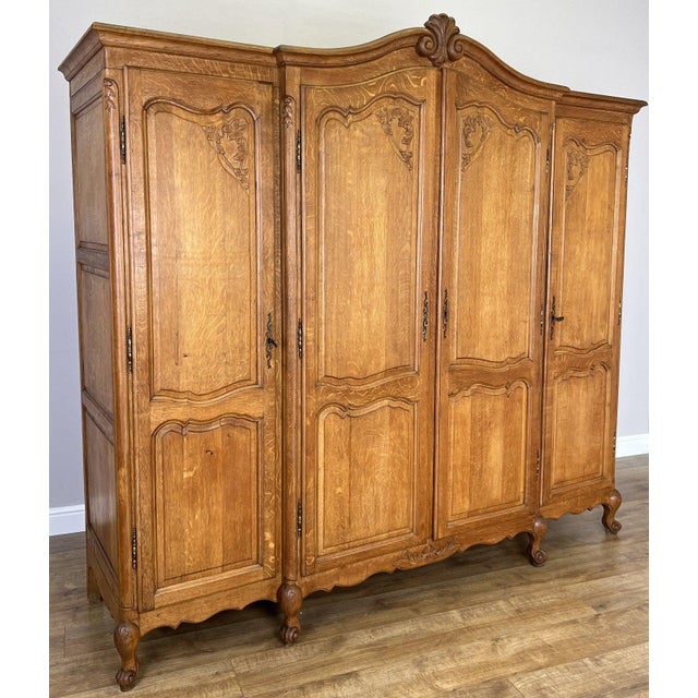 A beautifully crafted Vintage French Louis wardrobe with elegant carved detailing and a warm oak finish throughout. This...