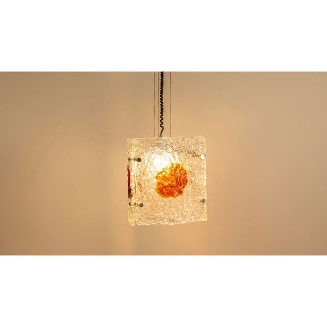 with its ice-like texture and amber-hued inclusions, this pendant lamp evokes the quiet elegance of 1970s Murano glass...