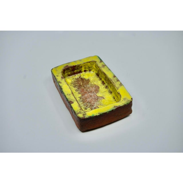 Brutalist stoneware trinket tray with vitreous glass base, yellow, green and brown, in good condition This piece has an...