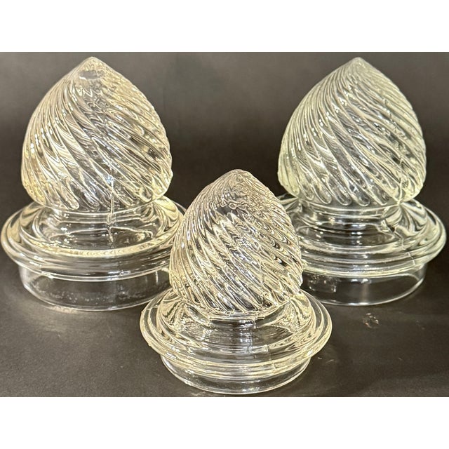 A beautifully proportioned set of three 19th-century molded glass apothecary jars with barley-twist lids and soft antique...