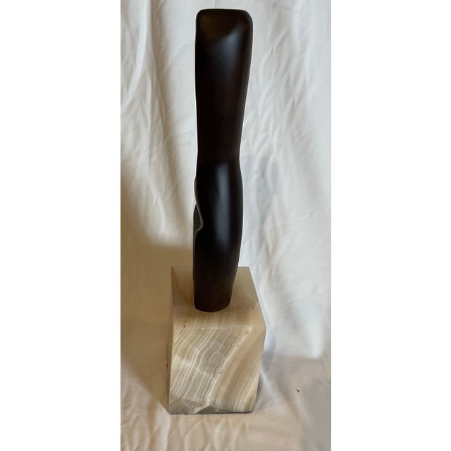 Unique hand-carved teach sculpture on an alabaster base