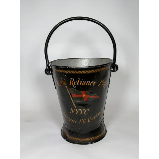 Early twentieth century ships deck bucket with heavy carry and bale handles. Painted black with later decoration that...