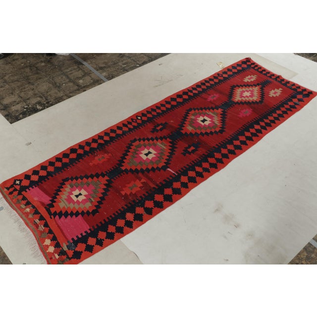Handwoven in wool circa 1920-1930, this 4x12 antique Persian Kilim exemplifies the richest colors and most classic tribal...