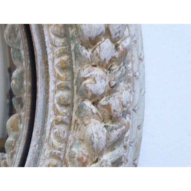 This carved, ivory whitewashed frame has a convex mirror and measures 19" in Diameter.